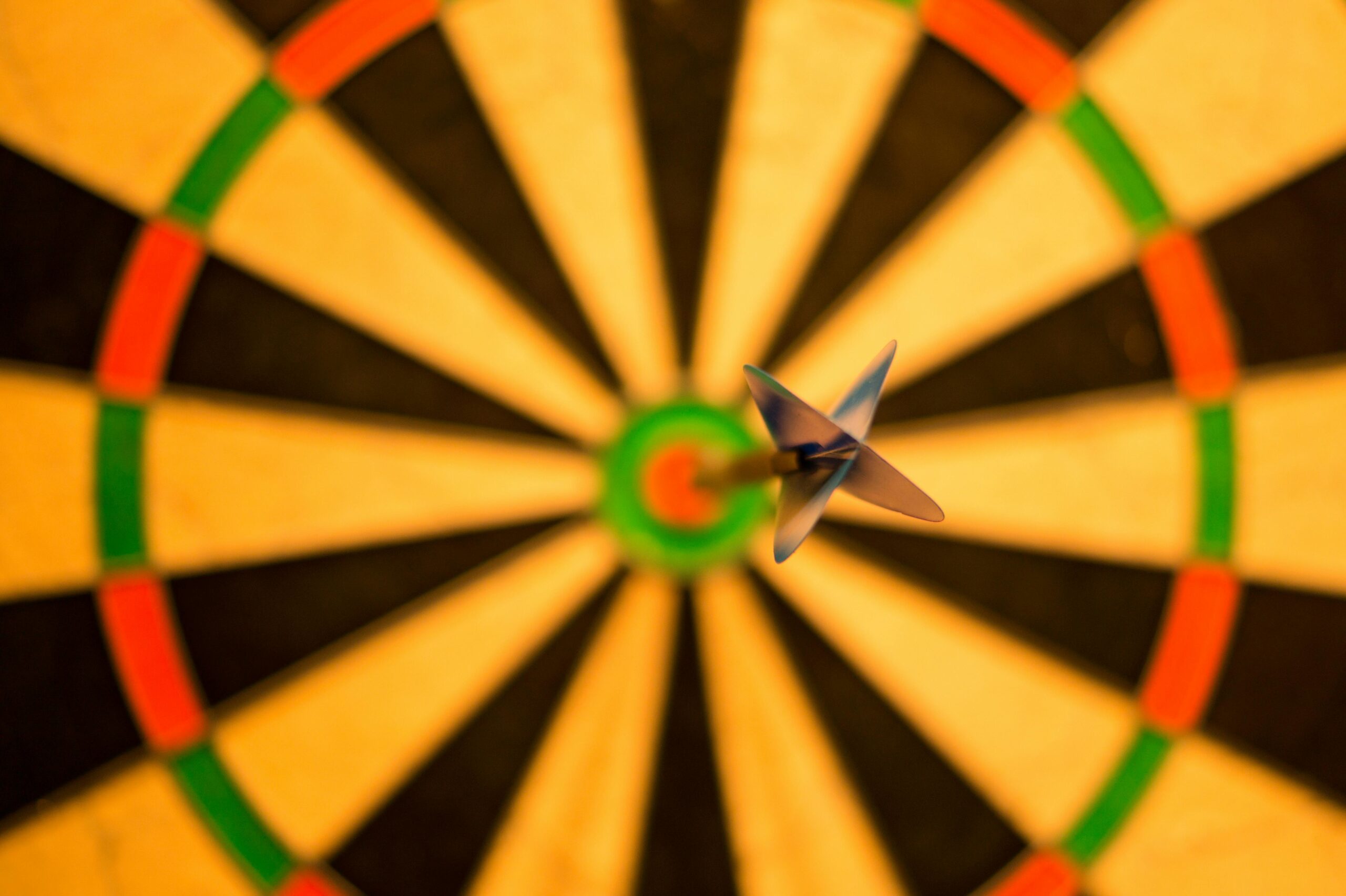 A close-up of a dart perfectly hitting the bullseye on a dartboard, symbolizing accuracy.